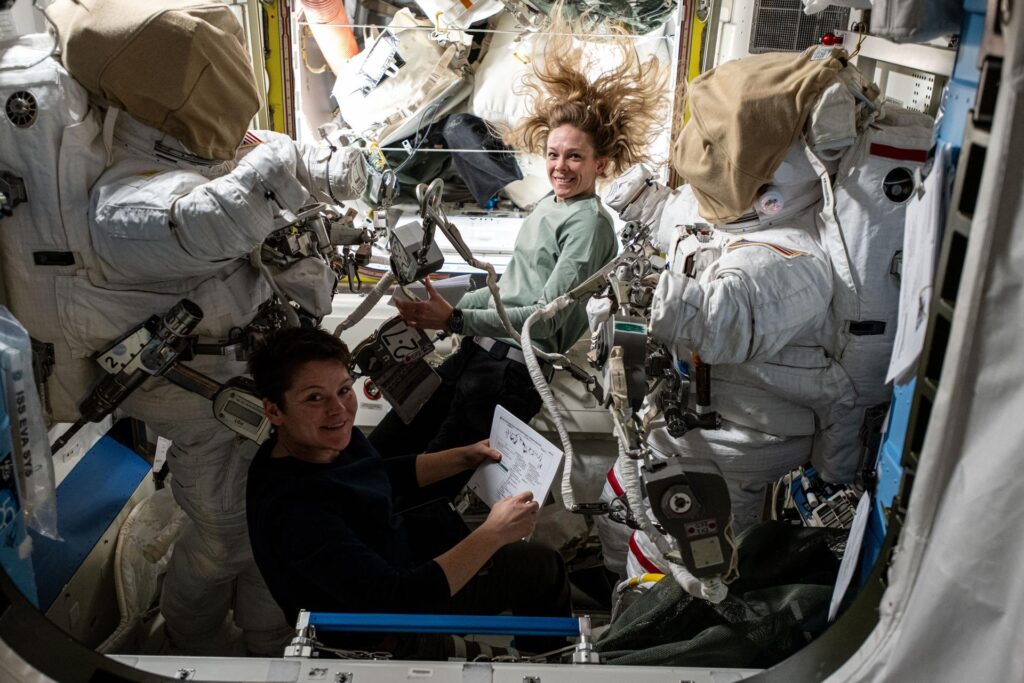 NASA astronauts Anne McClain (bottom) and Nichole Ayers (top), both Expedition 73 Flight Engineers, checkout spacesuit hardware in the Quest airlock and review procedures for a May 1 spacewalk.