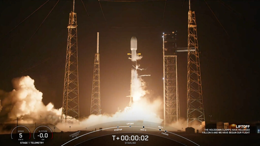a black and white rocket launches into a dark night sky